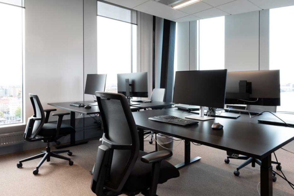 Ett ljust och öppet kontorslandskap hos Subset med grupper av svarta skrivbord och ergonomiska kontorsstolar.