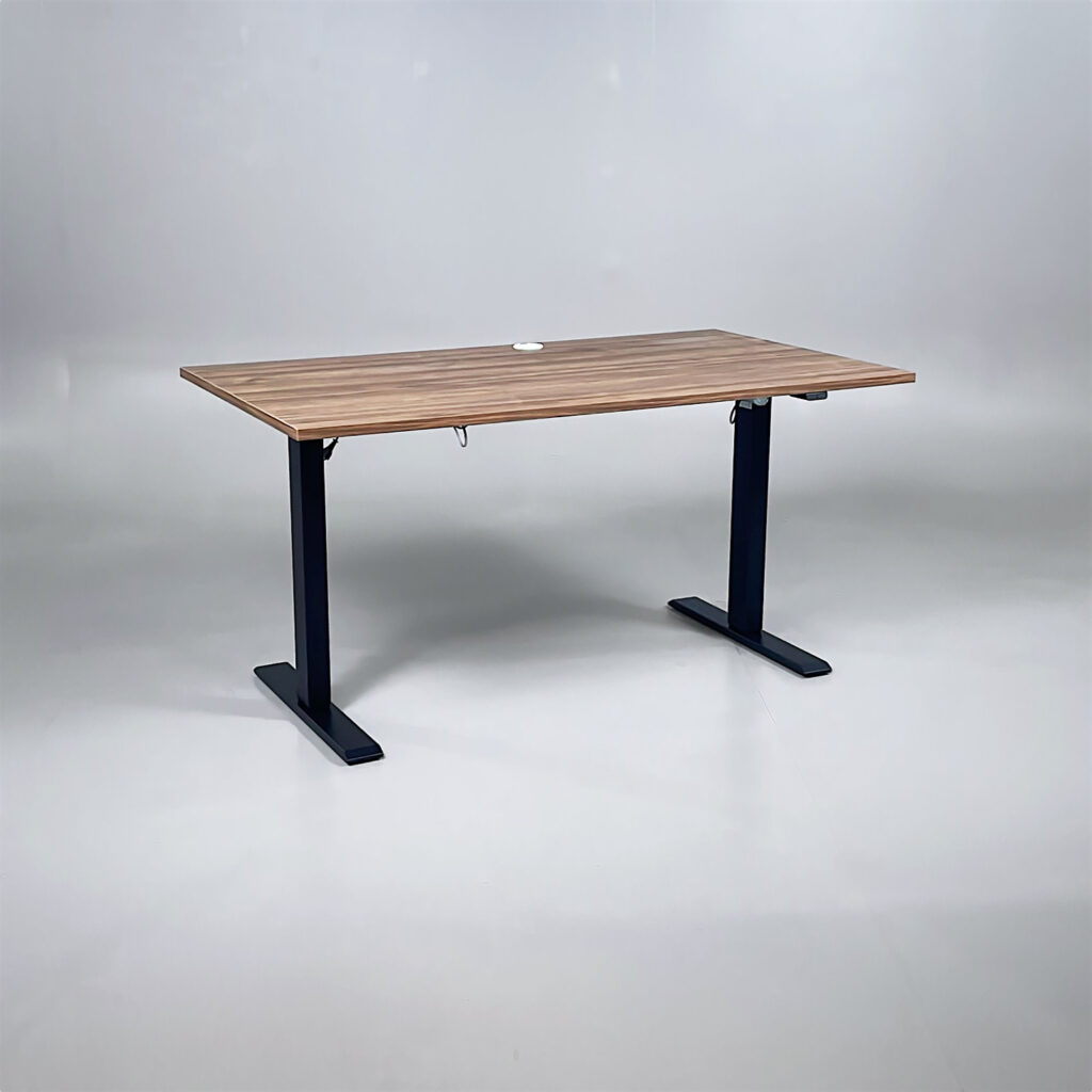 Ett skrivbord med mörk träskiva och svart höj och sänkbart stativ.