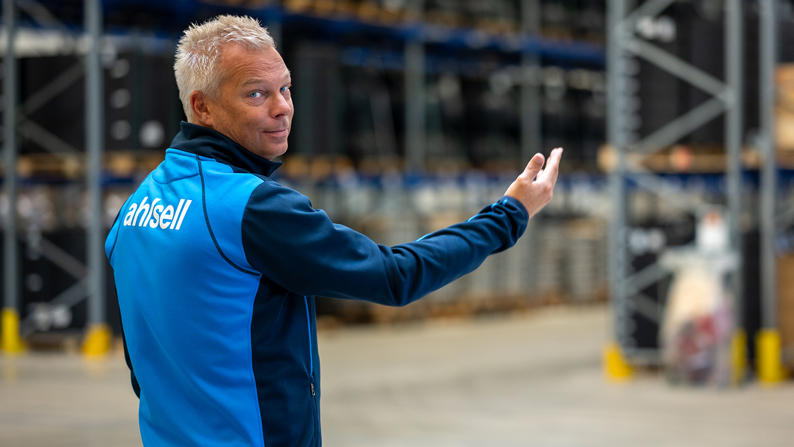 Jon Svensson visar lagerhyllorna inne på nya anläggningen