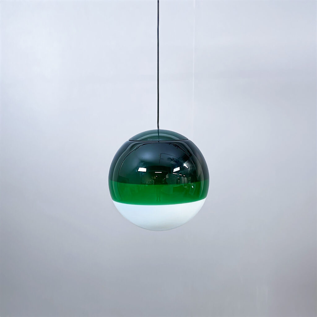 En rund taklampa i glas med en grön och vit design