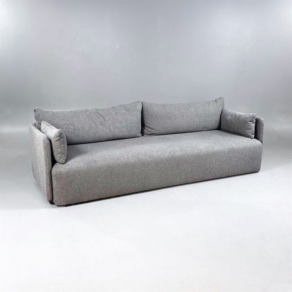 En minimalistisk, grå soffa med raka former och enhetlig stoppning.
