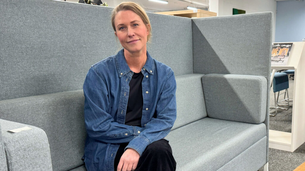 Inredningsarkitekten Annie Leonsson sitter i en grå tyst soffa