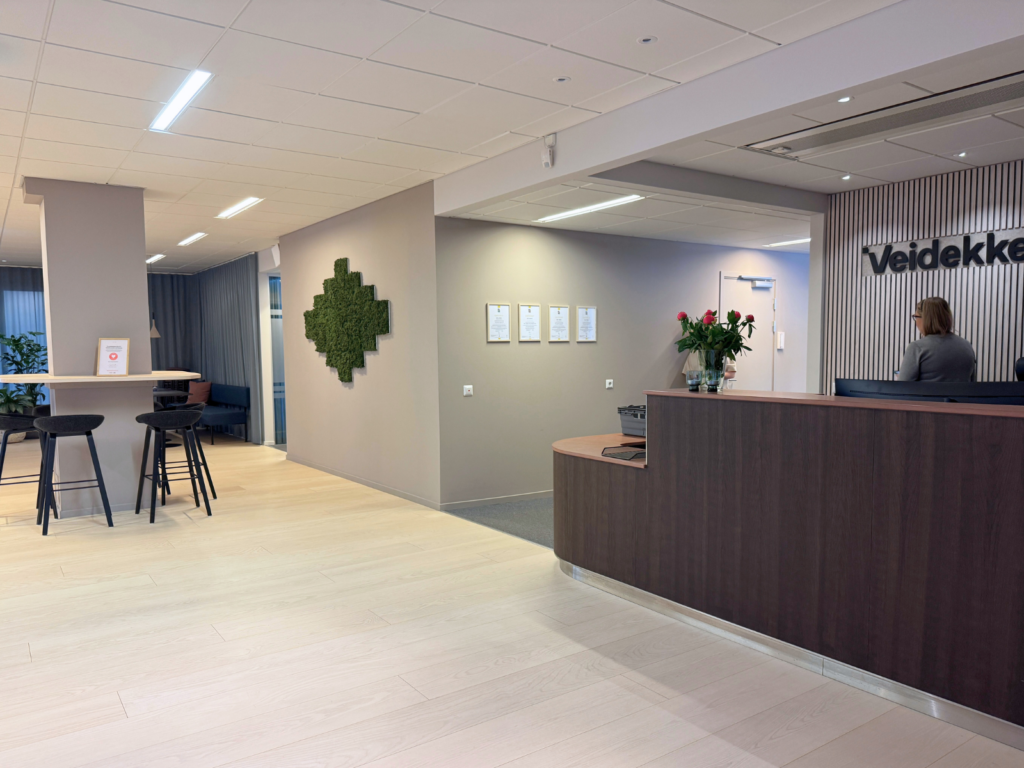 Stor reception i mörkt trä med texten Veidekke på väggen.