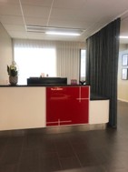 Reception med rödvit disk och grå drapering i bakgrunden.