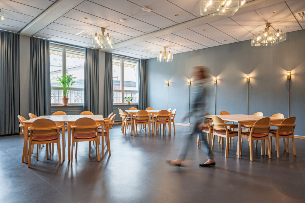Vantörs kyrka interiör - ett stort rum med blå väggar och runda bord med stolar